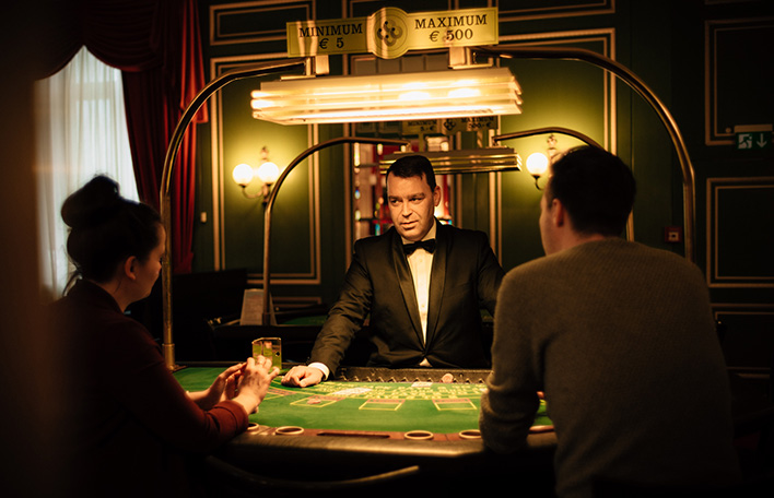 Szene am Black-Jack-Tisch: Ein Mann und eine Frau spielen gegen den Dealer.